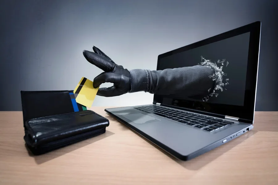 Một bàn tay từ laptop đang lấy cắp tiền