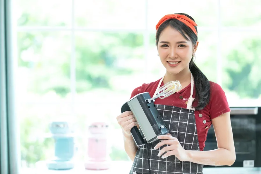 Một phụ nữ đang cầm máy đánh trứng điện