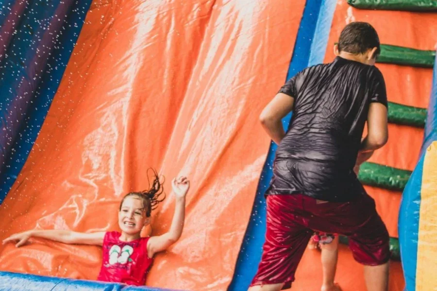 Kids playing in a colorful inflatable pool slide