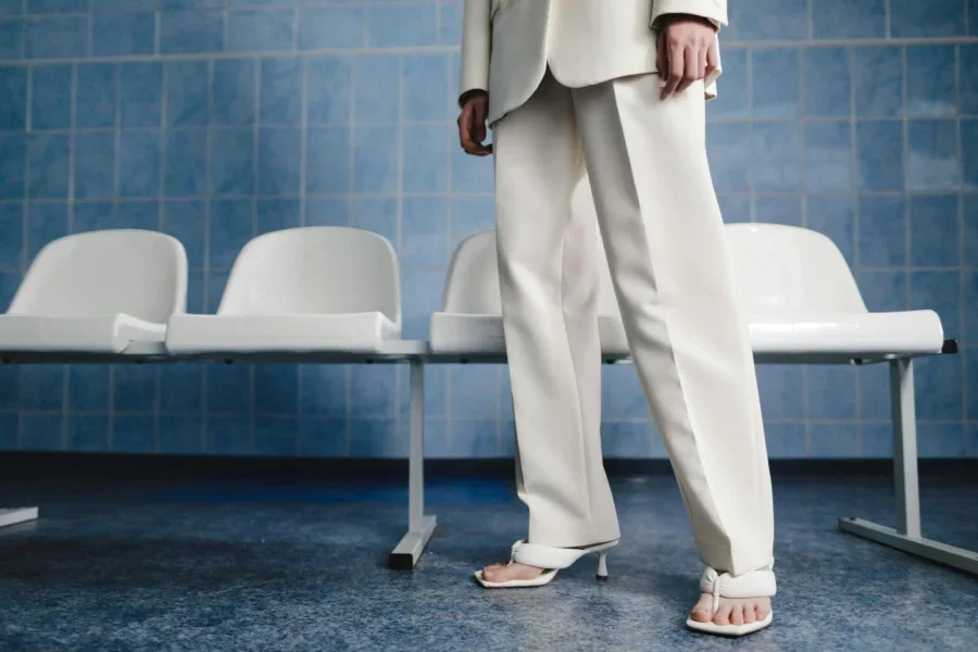 Legs of a Model in a White Suit and Low-heeled Sandals