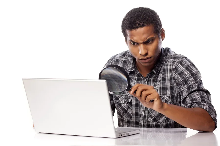 Người đàn ông đang kiểm tra kỹ điều gì đó trên laptop