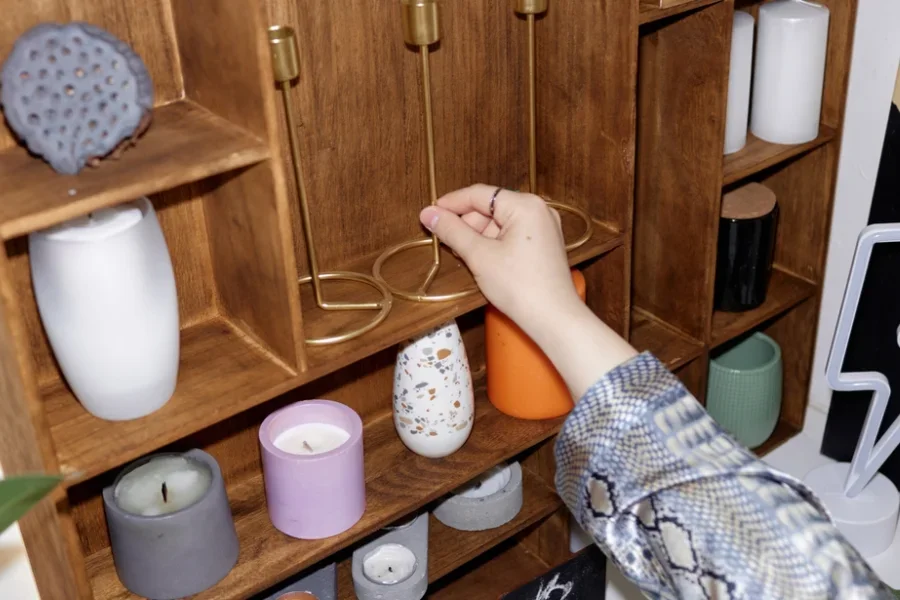 Người đang sắp xếp nến và giá nến trên kệ