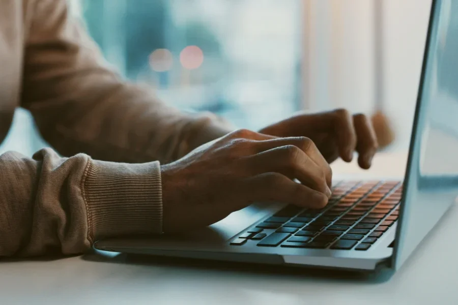 Người đang gõ tin nhắn trên laptop