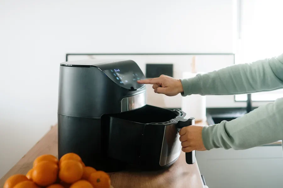 Người sử dụng một nồi chiên không dầu màu đen bóng bẩy