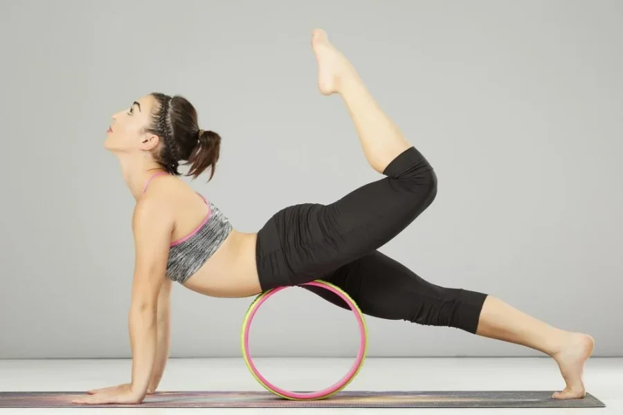 Người Phụ Nữ Kéo Giãn Với Bánh Xe Yoga