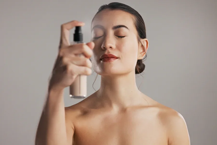 Người phụ nữ đang cố định lớp trang điểm bằng xịt