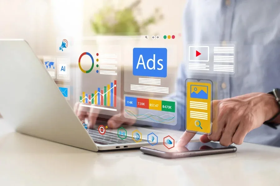 Người đang làm việc trên laptop và sử dụng điện thoại